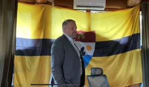 Vít Jedlička, the president of Liberland who follows right-libertarian principles, pictured in front of the country's flag during the Floating Man festival on August 6, 2023. Photo credit: Thomson Reuters Foundation/Adam Smith.